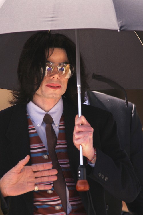 SANTA MARIA, CA - MAY 26: Singer Michael Jackson's bodyguard reaches for Jackson's umbrellas as he l